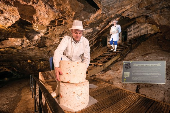 Picture of cheese being stacked in a cave